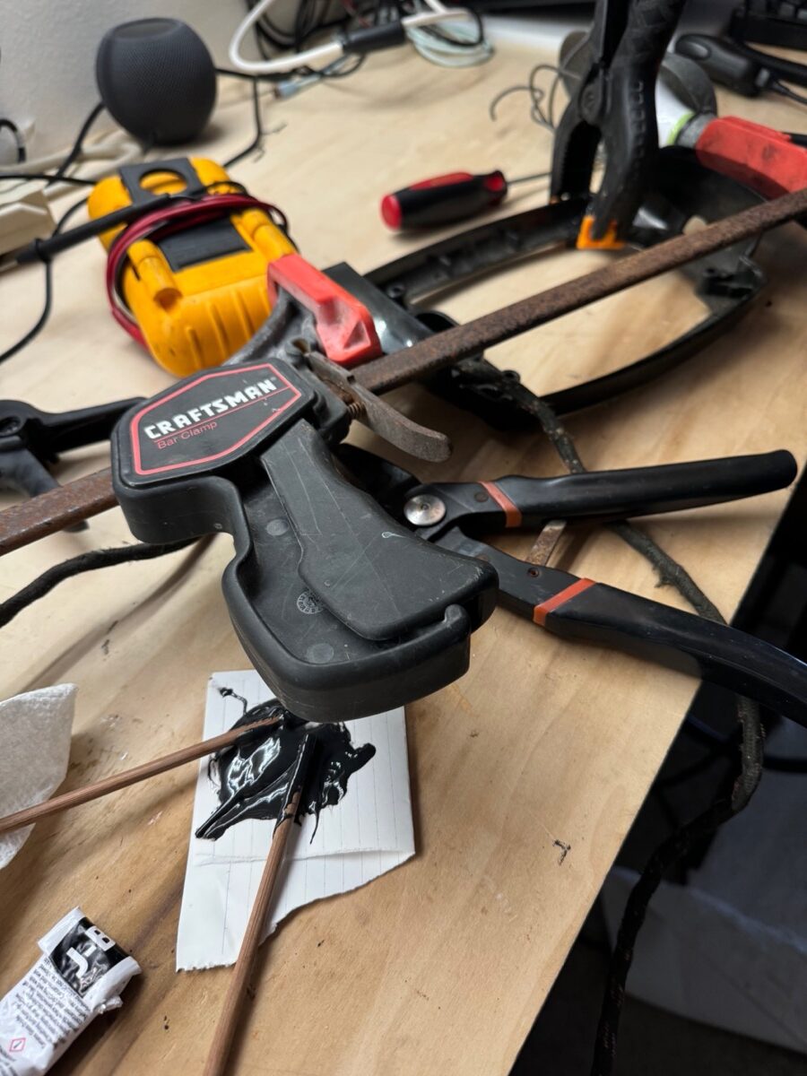 An overview of a large and small clamp holding together a bakelite base. 